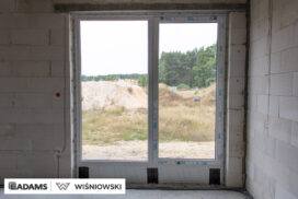 Nasze realizacje – Wiśniowski – Brama segmentowa UniTherm, okna PVC PRIMO 82, rolety zewnętrzne  Szukasz stolarki dla swojego domu, który ma być zarówno estetyczny, jak i energooszczędny? Zobacz naszą realizację, gdzie zastosowaliśmy kompleksowe rozwiązania Wiśniowski, gwarantujące funkcjonalność i niezawodność.  Lokalizacja realizacji: Drozdów  Okna PVC PRIMO 82 W tym projekcie postawiliśmy na okna PVC PRIMO 82, które wyróżniają się  świetnymi właściwościami izolacyjnymi. Na zewnątrz są w nowoczesnym kolorze - ciemnoszary jedwab, który idealnie pasuje do współczesnej architektury. Wewnątrz okna pozostały klasycznie białe (RAL 9016). Dodatkowo okna charakteryzuje bogate wyposażenie jak ciepłe ramki, zabezpieczenia antywłamaniowe, blokady antyprzeciągowe czy okucia z ukrytymi zawiasami.  Profil okien: PRIMO 82 Kolor zewnętrzny: Ciemnoszary jedwab Kolor wewnętrzny: Biały RAL 9016 Okucia: MACO MultiPower - zawiasy ukryte Wyposażenie: ciepła ramka, dwa zaczepy antywyważeniowe i najazd dolny, blokada antyprzeciągowa  Rolety Zewnętrzne Protecta P Dla zapewnienia prywatności i bezpieczeństwa zamontowaliśmy elektrycznie sterowane rolety zewnętrzne Protecta P. Ich pancerz PA-39 w kolorze szarego antracytu doskonale współgra z ramami okiennymi, tworząc spójną i elegancką całość. Rolety te to nie tylko świetna ochrona przed słońcem i hałasem, ale także dodatkowa bariera utrudniająca włamanie.  Rolety: Protecta P sterowane elektrycznie Pancerz: Pancerz PA-39 Kolor: Szary antracyt  Brama Segmentowa UniTherm Całość dopełnia nowoczesna brama segmentowa UniTherm w kolorze RAL 7016 (antracyt). Dzięki panelom typu G (bez przetłoczeń) brama wygląda minimalistycznie i bardzo elegancko, podkreślając nowoczesny styl budynku. Brama UniTherm to synonim najwyższej jakości, doskonałej izolacji termicznej i niezawodności, zapewniając łatwy i bezpieczny dostęp do garażu dzięki automatyce Wiśniowski SPARK 1100.  Brama: Segmentowa UniTherm Kolor: RAL 7016 Typ panela: G – bez przetłoczeń Automatyka: Wiśniowski SPARK 1100